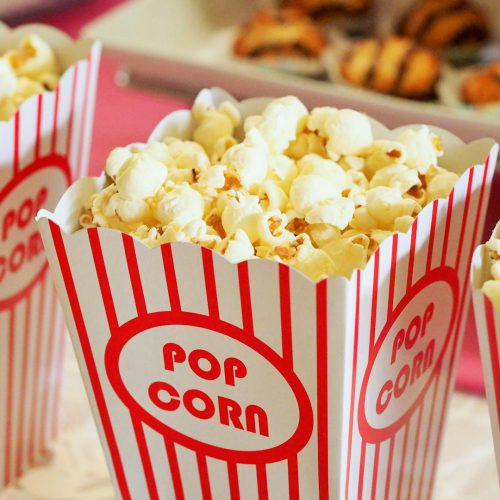 Photo by Pixabay Close-up of gourmet popcorn in classic red and white striped boxes, perfect cinema snack.